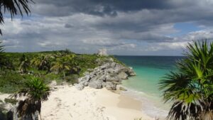 Zona arqueologica de Tulum sobre el acantilado, con playa de arena blanca y mar turquesa