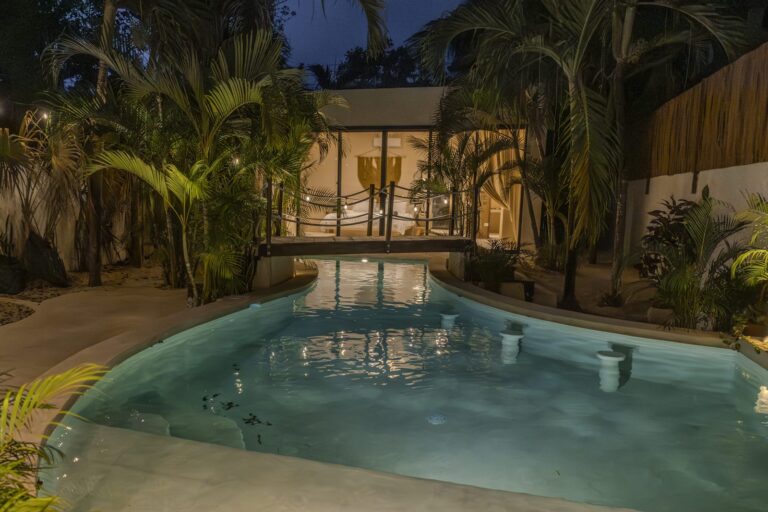 Alberca iluminada al atardecer en Villa Dulce Vida, Tulum